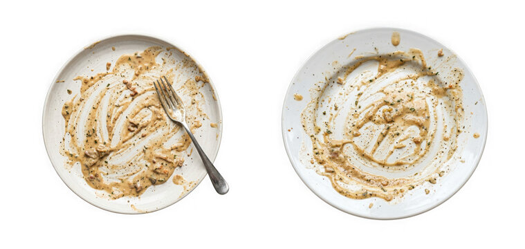 Two empty plates with leftover creamy sauce and a fork isolated on transparent background