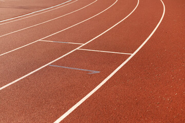 Fototapeta premium Red athletic running track with white lane markings