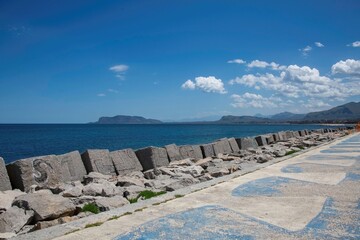 Fototapeta premium Palermo, Italy 05 13 2026: wave breaker and island at the coast of Palermo in Sicily