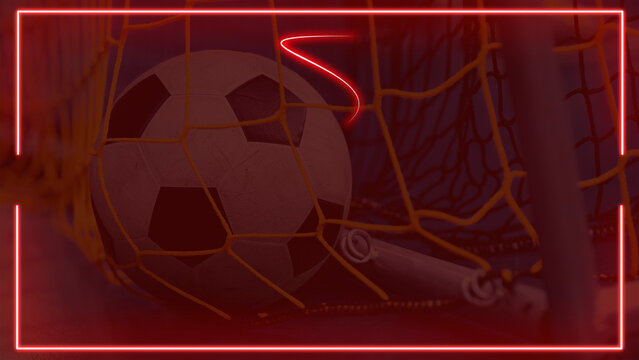 Soccer ball caught in goal net with red neon glowing frame background