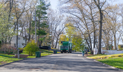 Naklejka premium trash collecting truck on residential street