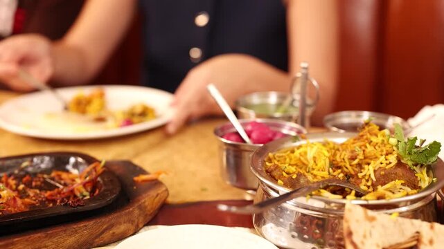 Woman Eating Traditional Indian Biryani and Naan at a Restaurant