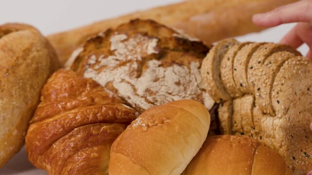 Hands Arranging Sliced Whole Wheat Bread and Assorted French Pastries