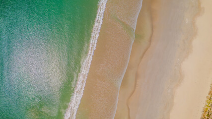 Aerial view of waves rolling onto a beach at Cape Northumberland, South Australia, with textured ocean patterns and foamy lines meeting the shoreline, capturing the raw, windswept beauty of Australia’ © Niki