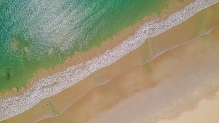 Aerial view of waves rolling onto a beach at Cape Northumberland, South Australia, with textured ocean patterns and foamy lines meeting the shoreline, capturing the raw, windswept beauty of Australia’ © Niki