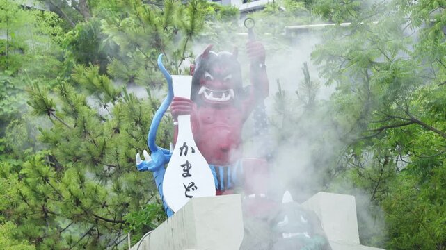 BEPPU, JAPAN - JUNE 2026: Traditional red Oni demon sculpture with volcanic vapor blowing around at a famous hot spring tourist attraction.