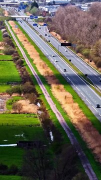 Vertical drone footage flying over a large French autoroute showing moving traffic, infrastructure, and surrounding countryside landscape from above.