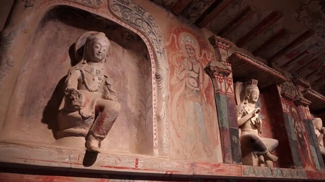 The mural art of the Mogao Grottoes in Dunhuang, China: Ancient Eastern art. Ancient Chinese murals, Mogao Grottoes in Dunhuang, Gansu Province, Buddhist statues, painted sculptures, and mural art.