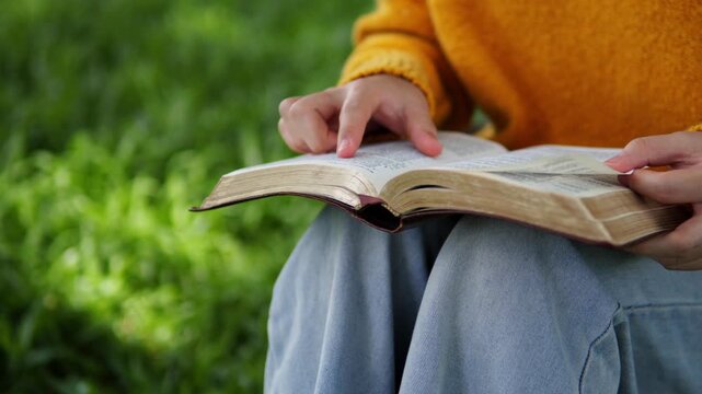 A young woman sits reading the Bible, learning about God during her quiet time seeking peaceful healing through love and His holy word.