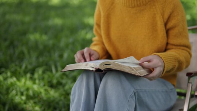 A young woman sits reading the Bible, learning about God during her quiet time seeking peaceful healing through love and His holy word.
