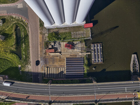 Wormerveer, Netherlands - 28 April 2026: Aerial view of a sheet piling rig crane and storage at the Meneba flourmill silo during the Zaankwartier redevelopment project by the water.