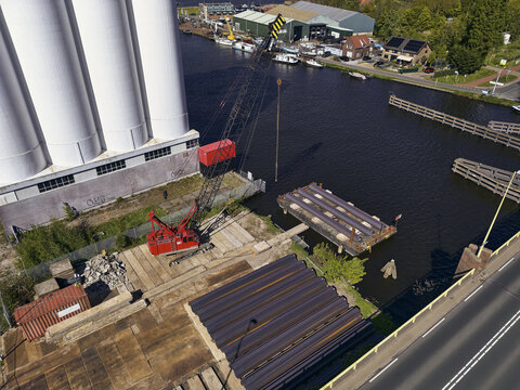 Wormerveer, Netherlands - 28 April 2026: Aerial view of the sheet piling rig crane and storage at the Meneba flourmill silo during the Zaankwartier redevelopment project.