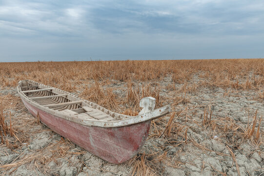 A traditional Iraqi Marsh Arab canoe known as a Mashoof abandoned on the dry earth of the southern marshes of Iraq, a wetland connected to the Euphrates River. During drought caused by climate change