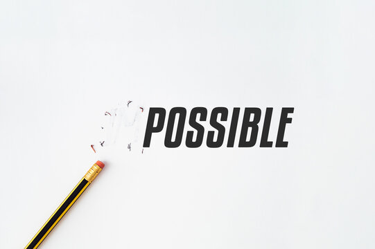 Creative conceptual image showing the word IMPOSSIBLE transformed into POSSIBLE by erasing the negative prefix with a pencil on white background. Motivational concept. Flat lay.