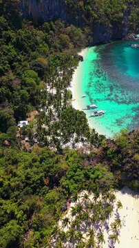 Drone aerial view of Seven Commandos Beach and Papaya Beach in El Nido, Palawan, Philippines. Tropical shoreline with turquoise water, white sand and limestone cliffs.