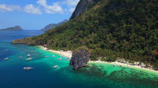 Drone aerial view of Seven Commandos Beach and Papaya Beach in El Nido, Palawan, Philippines. Tropical shoreline with turquoise water, white sand and limestone cliffs.