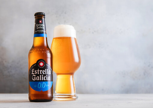 LONDON,UK - MARCH 19, 2026: Bottle and glass of Estrella Galicia alcohol free lager beer on light tsble background.