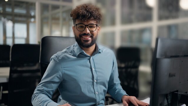 Arabian business man working using computer technology smiling happy positive looking at camera satisfied motivated successful ethnic businessman typing pc smile posing at work project male at office