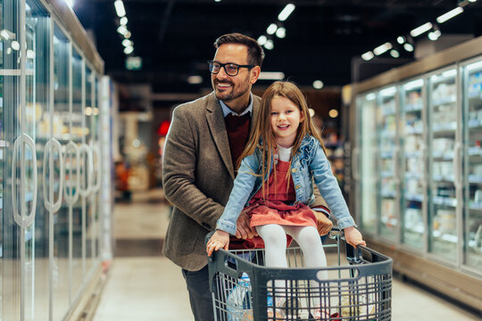 Father daughter enjoying grocery shopping together in supermarket