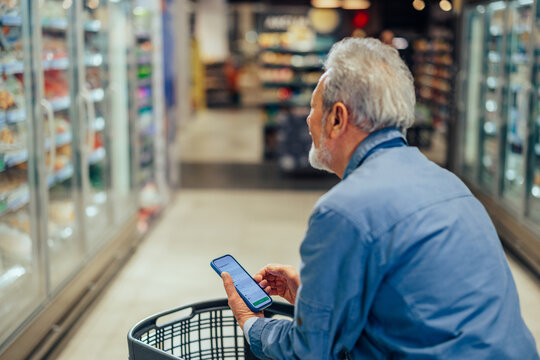Senior man using smartphone for grocery shopping