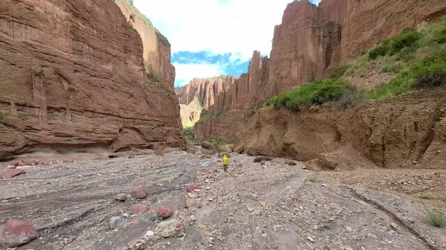 Hiker in Yellow Jacket Walking Through Palca Canyon Rock Formations in La Paz, Bolivia
