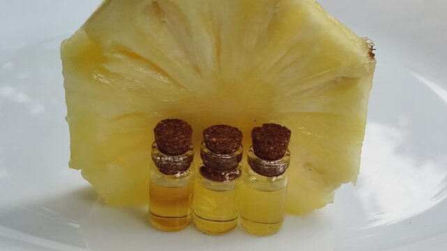 Pineapple or ananas fruit alternative food flavouring essence or enzyme extract inside glass bottle isolated on white background. Organic and natural oil for skincare, haircare beauty supplement use.