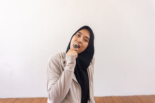 Young jilbab women is eatinig ice cream at home