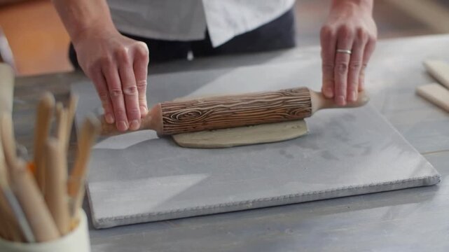 Person rolling out dough with a wooden rolling pin on a table