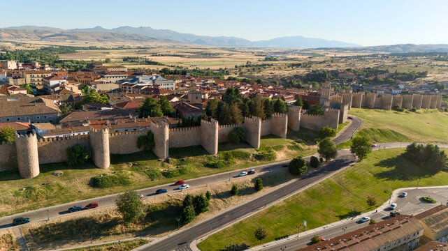 Aerial view of medieval stone walls of Avila with corner towers road and Castilian plains Spain