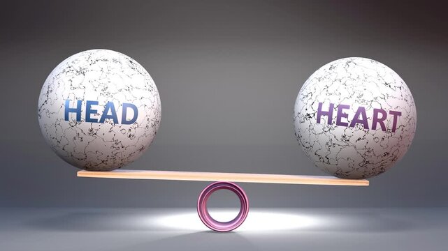Head and heart in balance - balancing stones on a scale symbolizing harmony, equity and equilibrium between head and heart. Harmonious and beneficial situation.