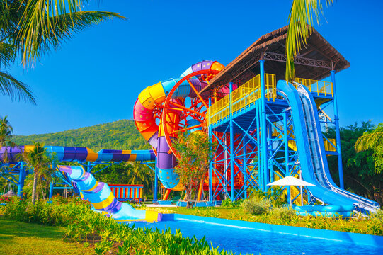 A tropical water park with colorful water slides and pools.