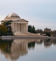 Obraz premium Beautiful springtime view of the Jefferson Memorial in Washington, DC, surrounded by blooming cherry blossoms and reflected in the Tidal Basin. 