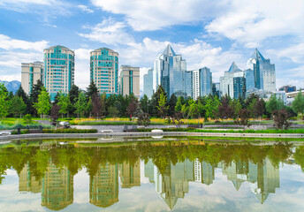 Fototapeta premium Modern Almaty skyline with glass skyscrapers and lake reflection in former presidential residence park, Kazakhstan