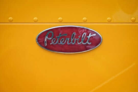 Senden , Germany - June, 06, 2026: Close-up of vintage peterbilt emblem on yellow truck. 