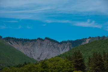Fototapeta premium Mountain ridges above green hills under blue sky