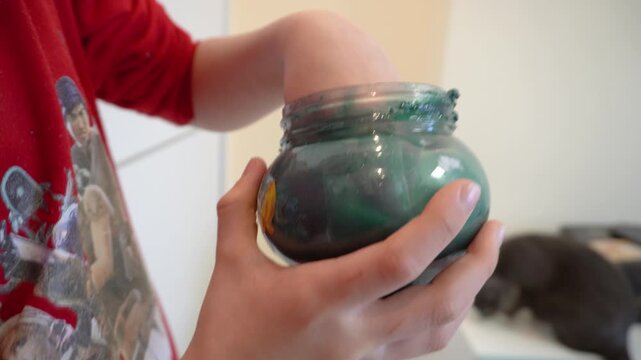 Child hands pulling spoiled slime close-up.