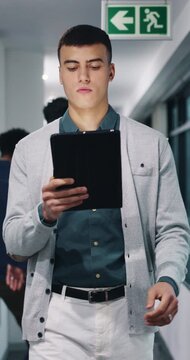 Walking, serious or man with tablet in hallway, review news article or proofreading story for publication. Tech, journalism or editor with grammar check for draft, research and verify feature facts