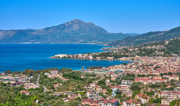 Panoramic coastal view of the seaside town of Sapri with turquoise water, mountains, and Mediterranean landscape under a clear blue sky. Sapri, Campania, Italy