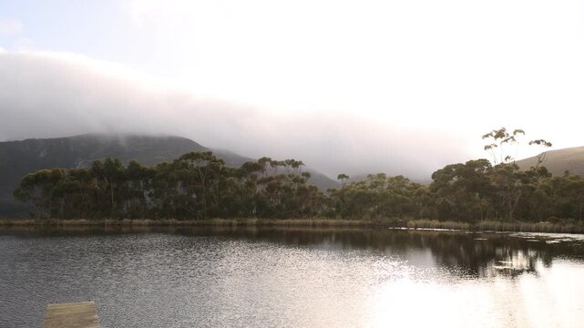 pond , grass , trees and Klein Mountains, Stanford, South Africa as the morning fog burns off