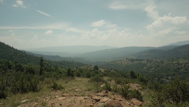 Panoramic view of rolling hills and valleys under cloudy sky