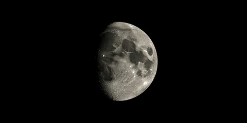 Fototapeta premium Moon surface textures visible on a smooth black background