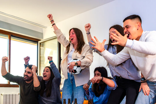 Excited football fans celebrating a goal during an international tournament at home