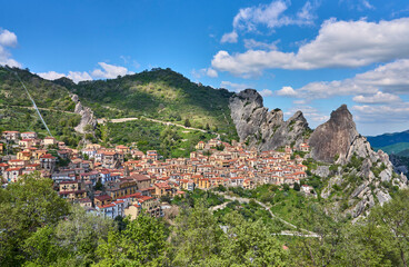 Obraz premium Picturesque panoramic view of Castelmezzano village nestled in the Lucanian Dolomites of the Apennine mountains, Basilicata, Italy. Colorful houses built on dramatic rocky cliffs