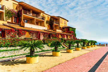 Obraz premium beautiful summer season touristic landscape in a green summer hotel with resort houses in traditional ilanian architecture style.