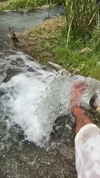Hand of msn making water spread from tubewell 