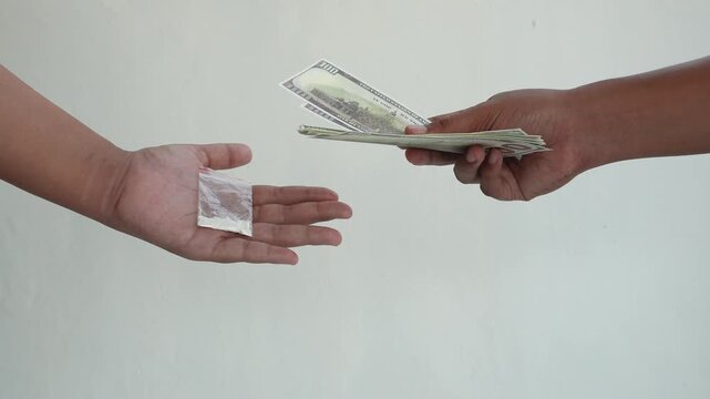 The concept of someone conducting a drug transaction. Two hands conducting an illegal drug transaction.