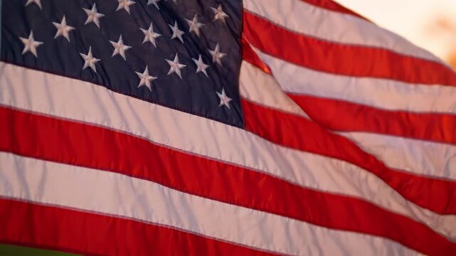 Close up of American flag waving in the wind during golden hour sunset