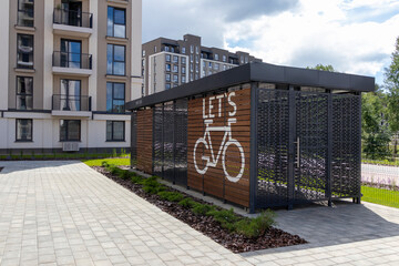 Naklejka premium Modern wooden bike box storage facility in a contemporary residential neighborhood. Urban