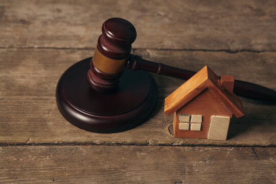 Wooden gavel and house on wooden table. Law concept.
