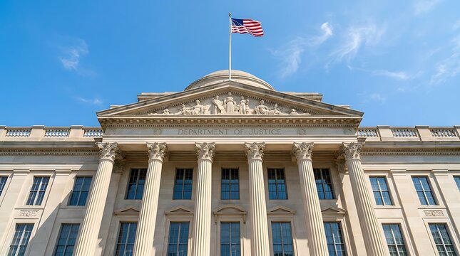 Department of Justice building in Washington DC with American flag flying under blue sky.